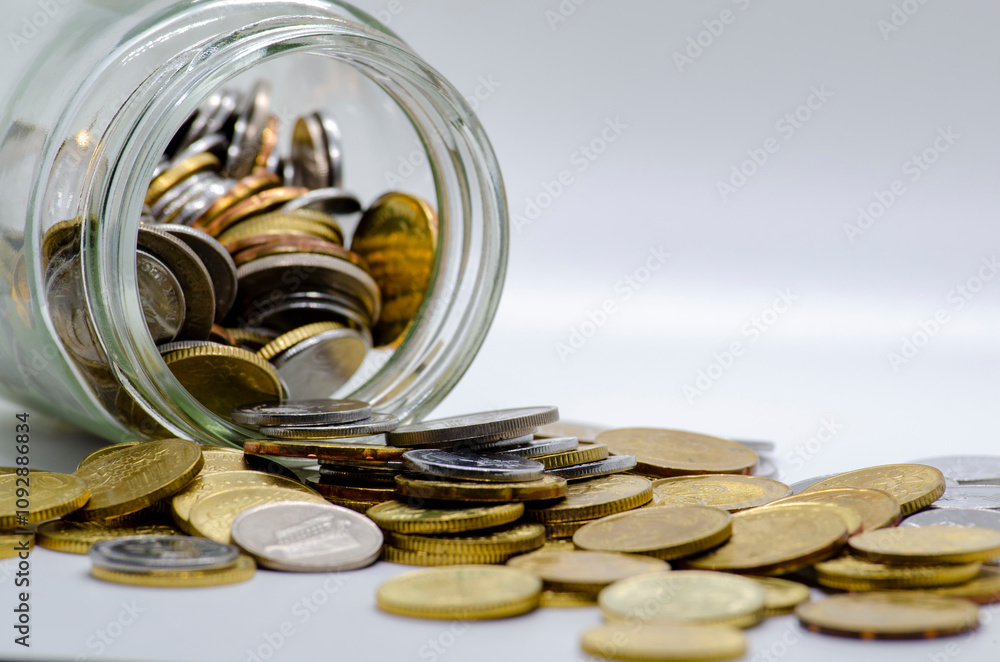 Coins in a jar with white background representing business, investment or any monetary concept. Customizable space for text Coins in a jar with white background representing business, investment or any monetary concept. Customizable space for text
