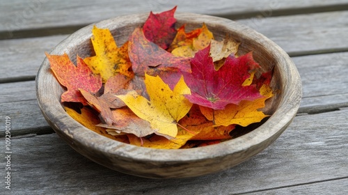 Colorful Autumn Leaves in Rustic Wooden Bowl on Natural Wooden Surface Showcasing Vibrant Fall Colors for Nature and Seasonal Decor