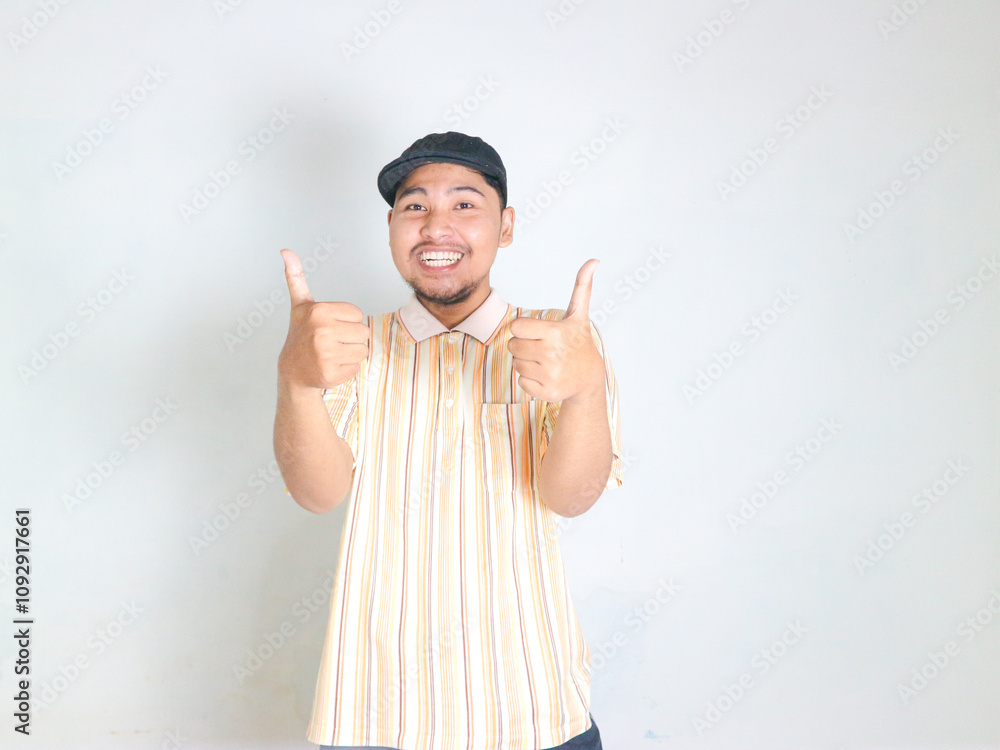 young asian man wearing striped polo shirt,raises both thumbs indicating that it is good young asian man wearing striped polo shirt,raises both thumbs indicating that it is good