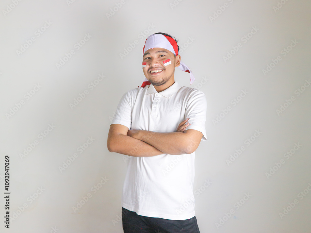 Happy young Indonesian man celebrate Indonesian independence day with arm folded feeling proud isolated on white background. Happy young Indonesian man celebrate Indonesian independence day with arm folded feeling proud isolated on white background.