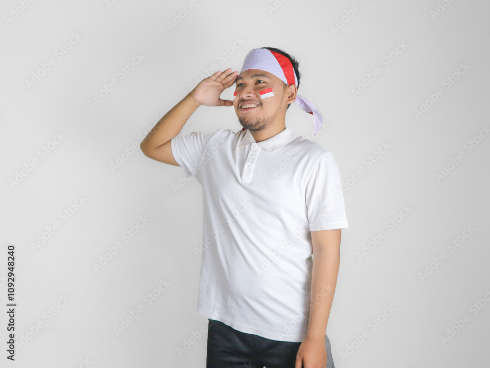 Handsome Asian man giving salute celebrate Indonesian independence day on 17 August isolated over white background Handsome Asian man giving salute celebrate Indonesian independence day on 17 August isolated over white background