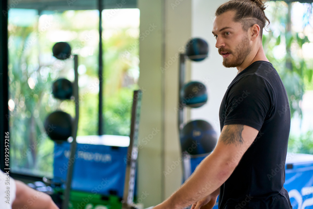 Handsome smart caucasian man in black shirt try to workout in sport gym by wieght training. Handsome smart caucasian man in black shirt try to workout in sport gym by wieght training.