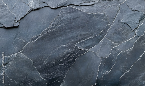 Dark grey slate stone texture background.  Natural stone surface with irregular cracks and crevices. Ideal for design projects needing a rugged, textured look. photo