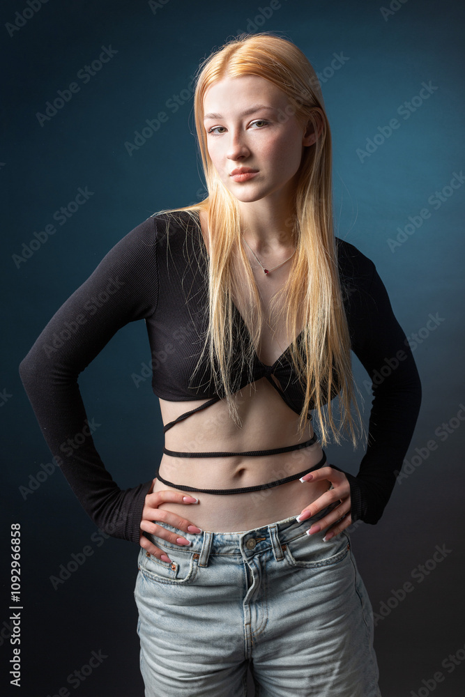 Portrait of a blonde woman with freckles in a sexy top and denim shorts in a studio. Portrait of a blonde woman with freckles in a sexy top and denim shorts in a studio.