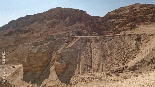 The caves and desert surrounding Qumran Nature Reserve, where the ancient Dead Sea Scrolls were discovered, on a dry summer day, highlighting their historic and sacred significance - Israel.