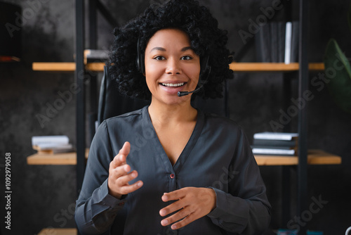 Foto Confident African female manager office worker in headphones head shot portrait