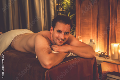 Quadro su tela Caucasian man customer enjoying relaxing anti-stress spa massage and pampering with beauty skin recreation leisure in warm candle lighting ambient salon spa at luxury resort or hotel