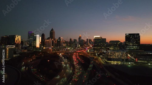 Stunning aerial drone photograph capturing Atlanta's mesmerizing cityscape at night. This wide-angle view showcases the city's iconic skyline, illuminated by vibrant neon lights and bustling highways.