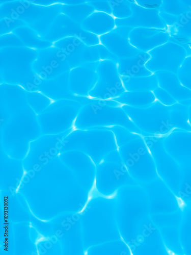 Soft blue waves undulate beneath the surface, creating a serene atmosphere in a tranquil swimming pool setting