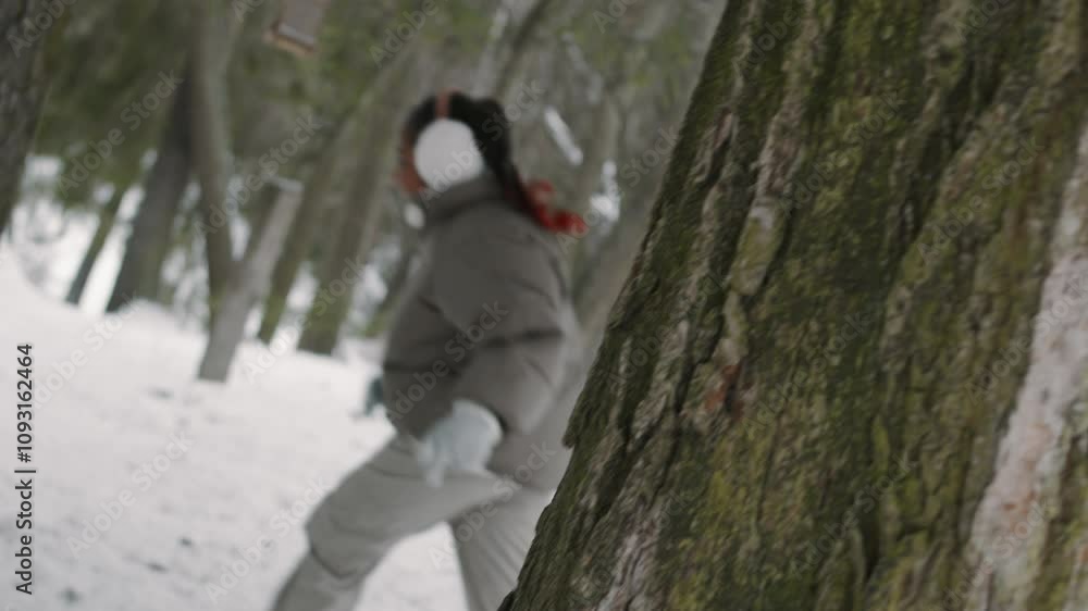 Smiling African American young parents chasing their positive teenage daughter who running from them in winter forest while spending time outdoors Smiling African American young parents chasing their positive teenage daughter who running from them in winter forest while spending time outdoors