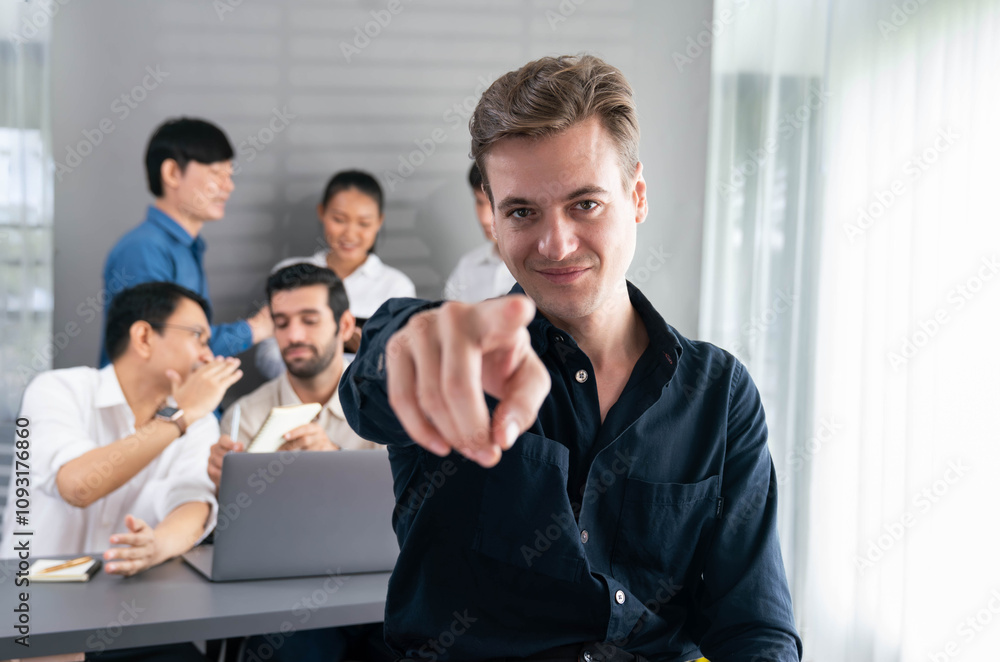 Obraz premium Confidence and happy smiling businessman portrait with background of his colleague and business team working in office. Office worker teamwork and positive workplace concept. Prudent