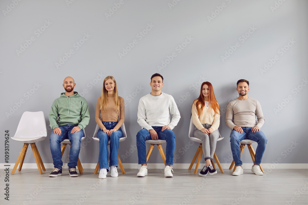 Naklejka premium Group portrait of young happy people chair sitting in easy pose, one vacant place. Diverse, together as team, friends gathered showing liking, affection and support, fellows in good relationships