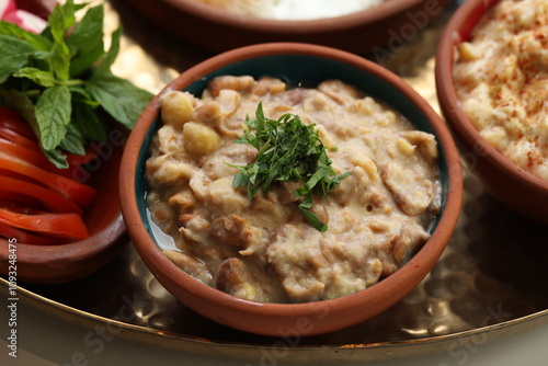 A bowl of creamy foul medames, a traditional Lebanese breakfast dish made with fava beans and chickpeas, garnished with fresh parsley, served in a rustic ceramic bowl.