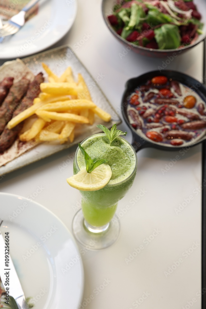 A refreshing mint lemonade served in a tall glass, garnished with a lemon slice and fresh mint leaves, offering a vibrant and cooling beverage option. A refreshing mint lemonade served in a tall glass, garnished with a lemon slice and fresh mint leaves, offering a vibrant and cooling beverage option.