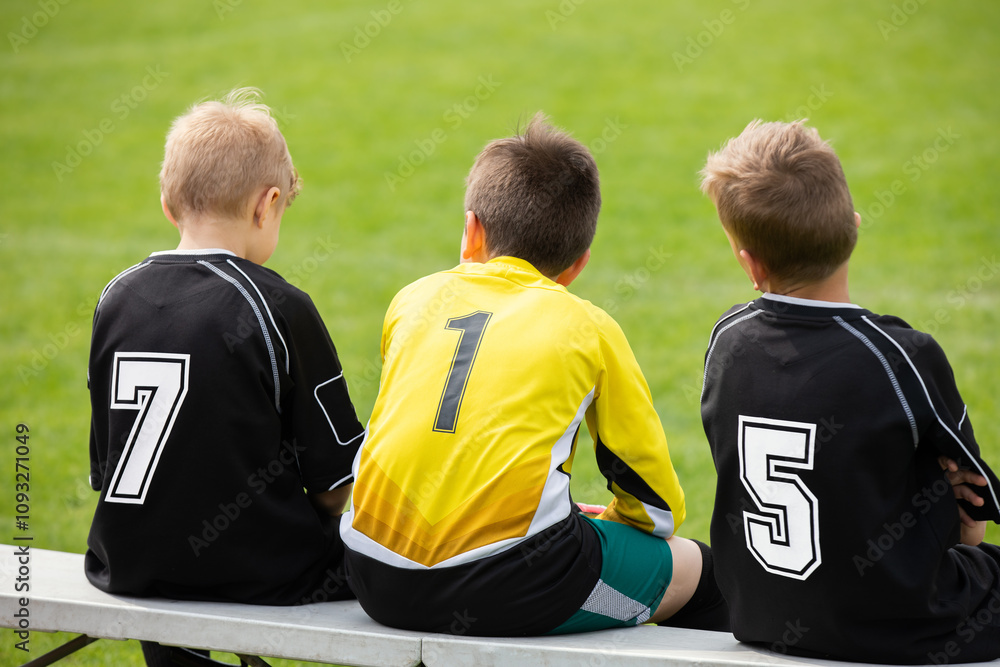 School Soccer Boys in Uniforms. Players Sitting on Soccer Bench. European Football Children Play Sports in Sunny Day School Soccer Boys in Uniforms. Players Sitting on Soccer Bench. European Football Children Play Sports in Sunny Day