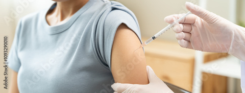 People getting a vaccination to prevent pandemic concept. Woman in medical face mask  receiving a dose of immunization coronavirus vaccine from a nurse at the medical center hospital