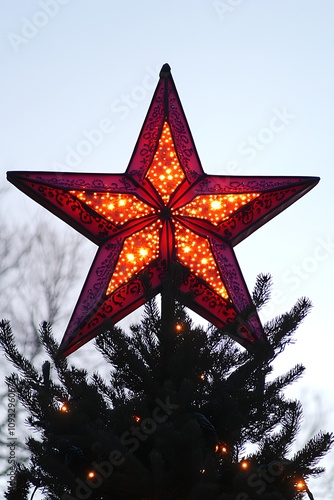 Wide-angle shot ofsingle glowing Christmas star atopfrosted tree, framed byclear, starry sky, printspace ,Silhouettes, high-contrast lighting, sunset hues photo