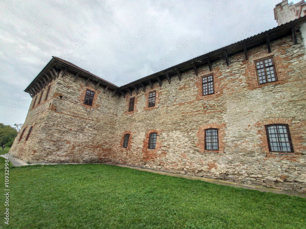 A large stone building with a green lawn in front of it A large stone building with a green lawn in front of it