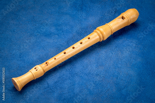 Fotografie wooden recorder flute instrument, classic German style, against art paper