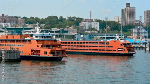 New York, USA, August 16, 2024. Footage at the Staten Island dock, we pass by other moored ferries with the characteristic orange color and the writing on the side.