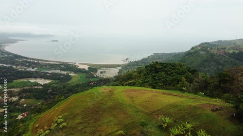 aerial 4K view of Ciletuh hill Sukabumi in tropical beach. no clear water and blue sky, hazy and cloudy. Pelabuhan Ratu Beach, Java Indonesia photo