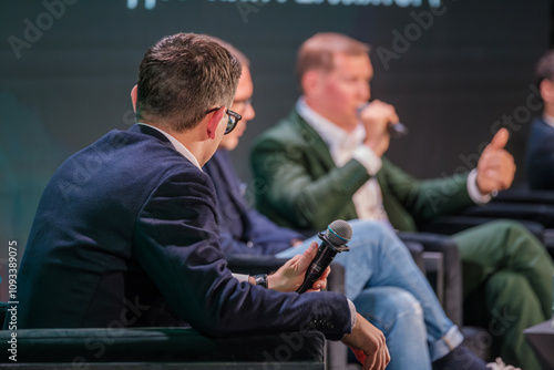 Wallpaper Mural Corporate leaders engaging in discussion on stage with microphones and audience. Professional conversation during formal event. Torontodigital.ca