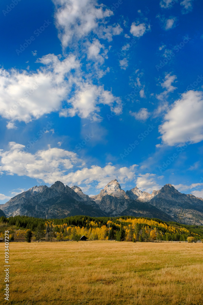 Grand Teton Mountains Tetons in Wyoming Rugged Mountain Range in Autumn Fall Landscape with blue sky and clouds Grand Teton Mountains Tetons in Wyoming Rugged Mountain Range in Autumn Fall Landscape with blue sky and clouds
