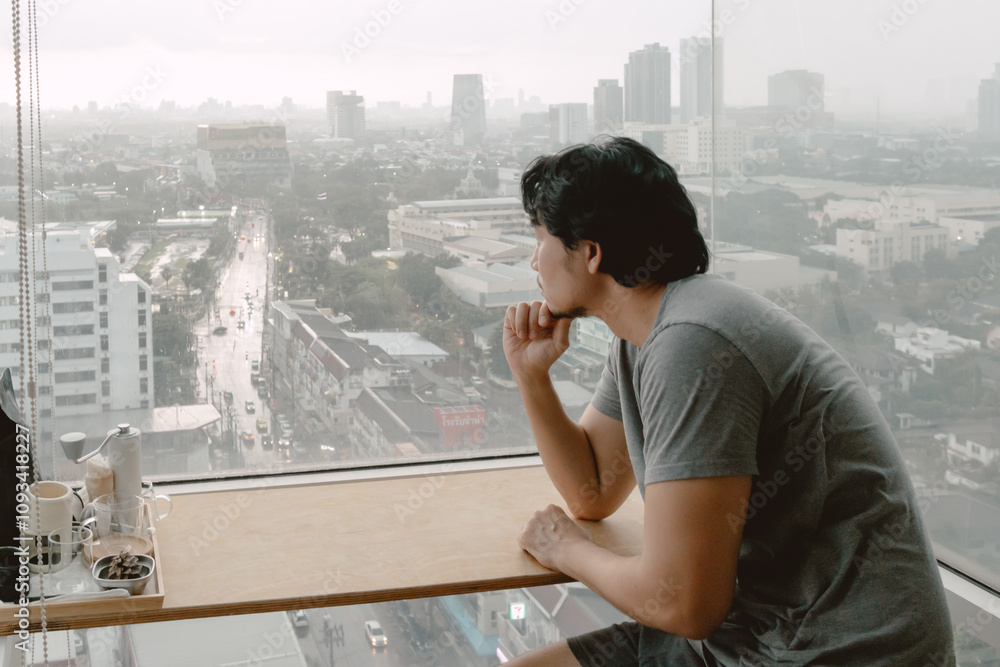 Lonely single asian man looking out to through the windows of apartment. Lonely single asian man looking out to through the windows of apartment.