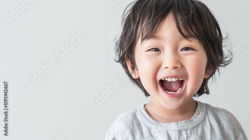 An Asian child with a toothy grin showcasing their prominent front teeth.