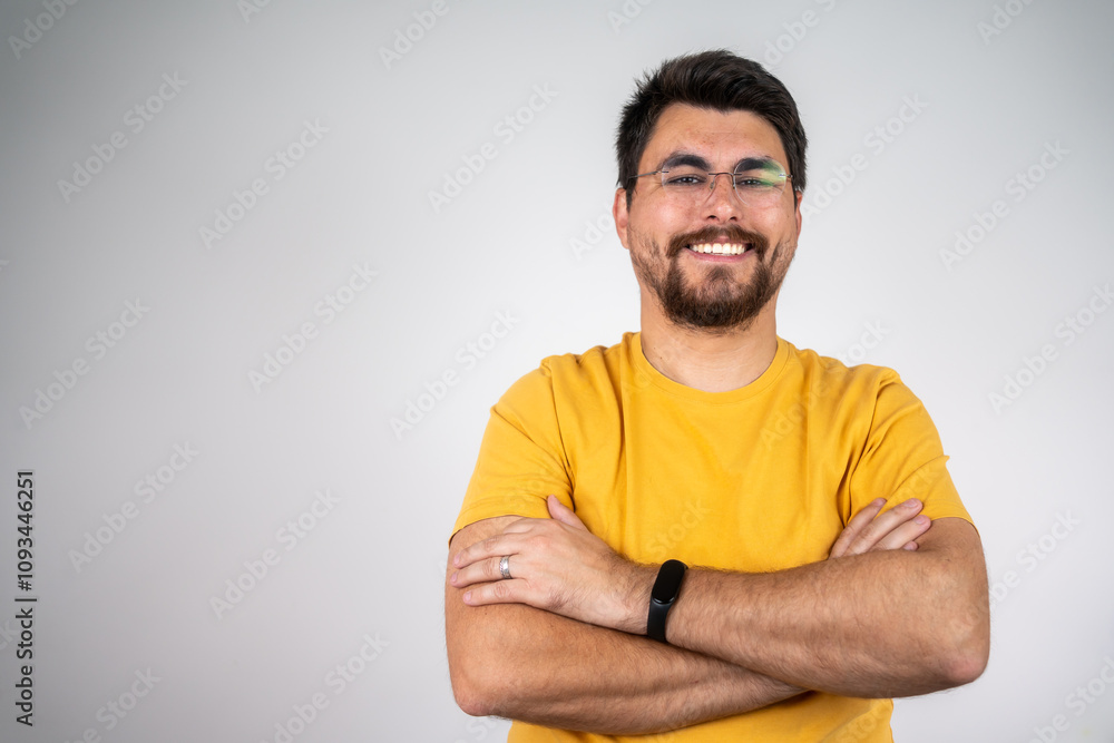 Portrait of handsome smiling young man with folded arms. Smiling joyful cheerful men with crossed hands studio shot. Isolated on gray background Portrait of handsome smiling young man with folded arms. Smiling joyful cheerful men with crossed hands studio shot. Isolated on gray background