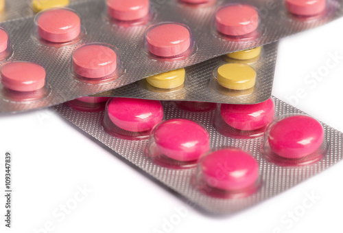 colored medical pills pink and yellow on white background