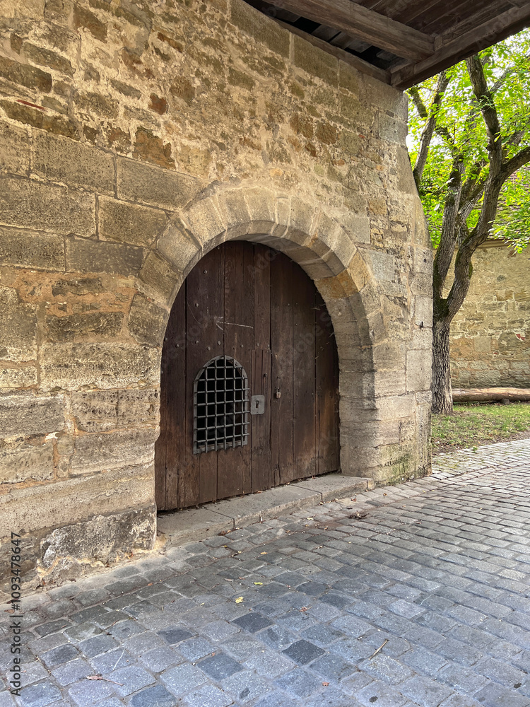 Fototapeta premium Door with grate in the wall of hospital bastion Spitalbastei, Rothenburg ob der Tauber, Bavaria, Middle Franconia, Germany