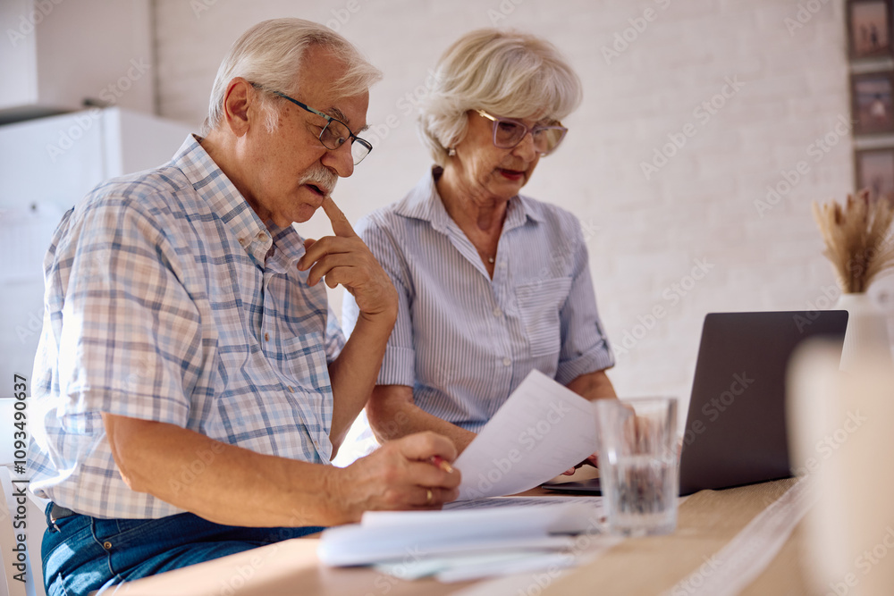 Pensive senior man analysing financial bills with his wife at home. Pensive senior man analysing financial bills with his wife at home.