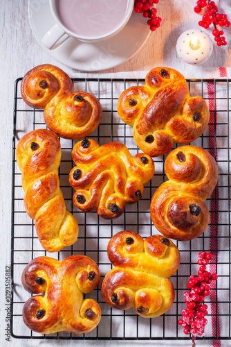 Obraz na płótnie Traditional saffron Swedish buns lussekatt in different shapes, served with cocoa on a wooden table. Buns for St. Lucia's Day. w salonie