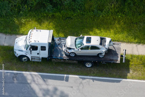 фотографія Car crash site with tow truck loading destroyed vehicle on American street