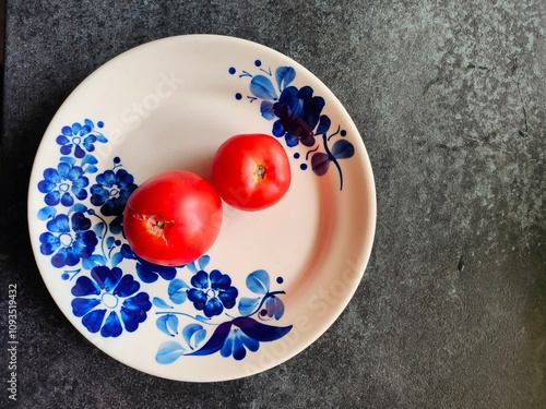 red tomatoes on a white plate decorated with blue flowers