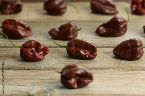 Brown Habanero peppers on wooden background, Habanero Chocolate, selective focus, bokeh, red habanero background, pepper background, space for text, copy space.