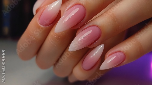 Close-up of elegant, pale pink ombre nails with a sharp, stylish point shape. photo