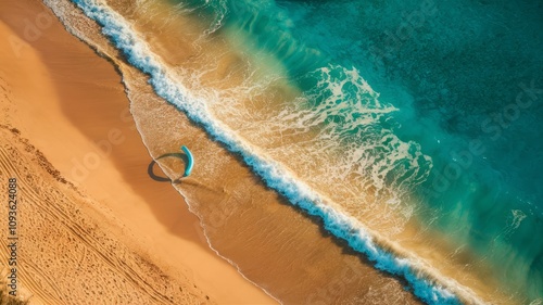 Azure Waves on Sandy Shores: Aerial view showcases a picturesque beach, the meeting point of golden sand and vibrant turquoise water. A kitesurfer adds a dynamic element to the scene. 