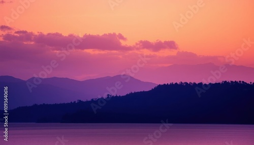 purple and orange sky over mountains and lake with boat in foreground