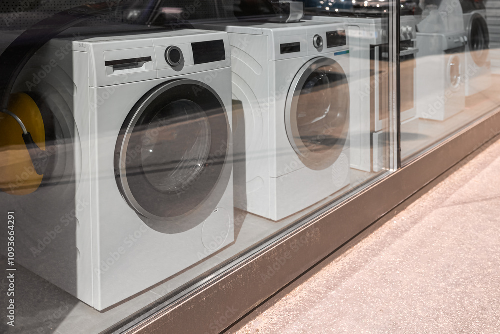 View of shop window with modern washing machines in store View of shop window with modern washing machines in store