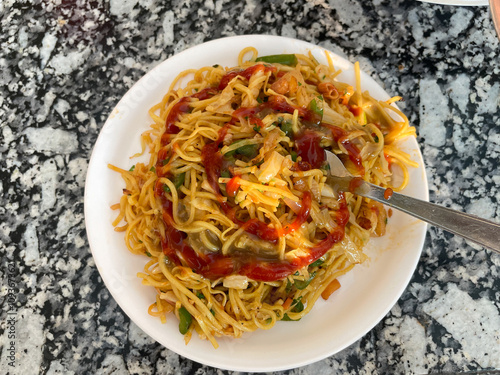 Noodles served in a plate, also known as chowmein. photo