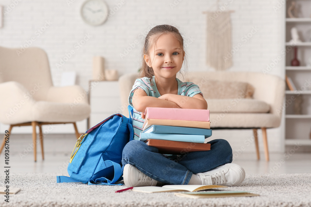 Cute little girl with books and backpack sitting on floor at home Cute little girl with books and backpack sitting on floor at home