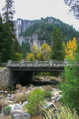 photo of masonry rock bridge over a stream in Zion National Park with a bluff and deciduous trees in autumn in background photo