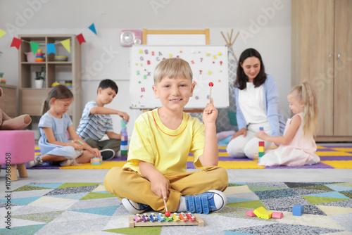 Little boy playing xylophone in kindergarten