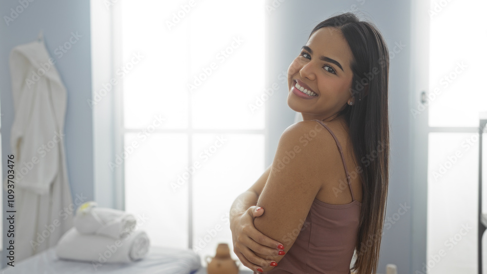 Woman smiling in spa room with towels in background, reflecting beauty, wellness, and relaxed atmosphere. Woman smiling in spa room with towels in background, reflecting beauty, wellness, and relaxed atmosphere.