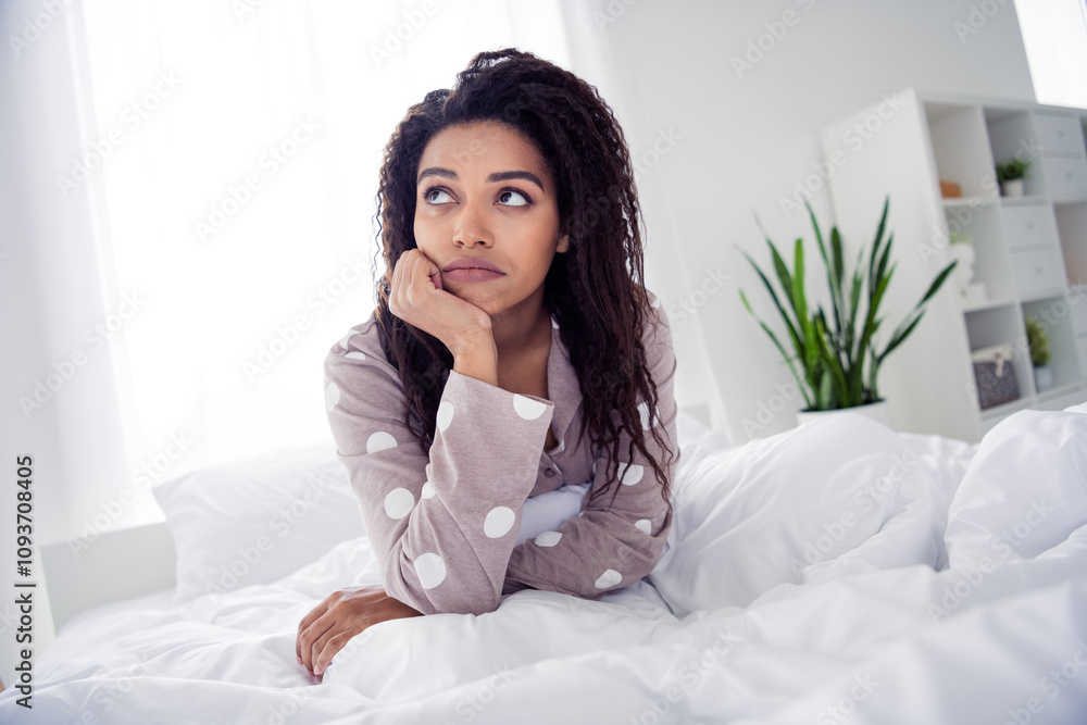 Young woman in polka dot pajama relaxing in cozy bedroom with natural light and peaceful atmosphere Young woman in polka dot pajama relaxing in cozy bedroom with natural light and peaceful atmosphere