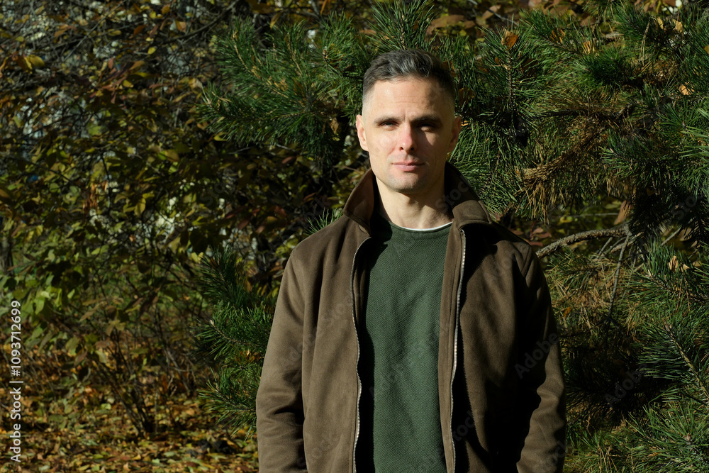 Man enjoying a sunny autumn day in a lush green park surrounded by colorful foliage Man enjoying a sunny autumn day in a lush green park surrounded by colorful foliage