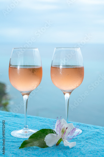 Summer time in Provence, two glasses of cold rose wine with blue sea view on background, French Riviera near Menton, south of France photo