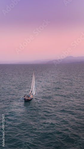 Aerial view of serene sailboats on little wave blue sea